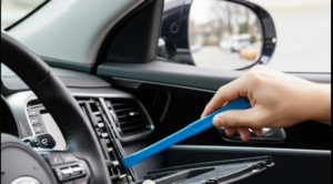A person disconnecting a car battery's negative terminal with a wrench during a DIY remote start installation.
