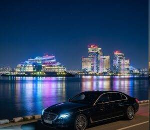 Seoul Night View Private Tour: A high-end sedan parked by the Han River at night, with the futuristic, illuminated Sebitseom islands in the background, setting the tone for a luxury Seoul private tour.