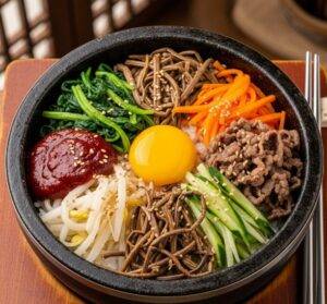 A top-down view of a vibrant Korean dolsot bibimbap in a hot stone bowl, with a bright egg yolk in the center.