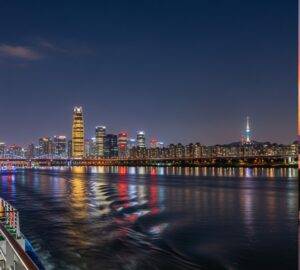 Stunning night view of the Seoul skyline, including the 63 Building and N Seoul Tower, as seen from a Han River cruise. A must-see for tourists.