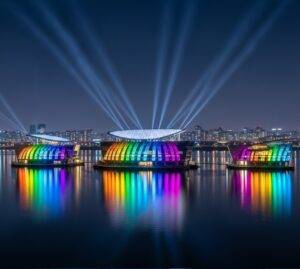 The three Sebitseom (Some Sevit) floating islands on the Han River, glowing with vibrant, colorful lights against the dark night sky of Seoul.