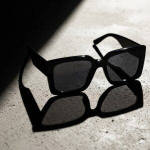 A close-up, editorial photograph of the Gentle Monster 'Rococo 01' oversized black sunglasses.