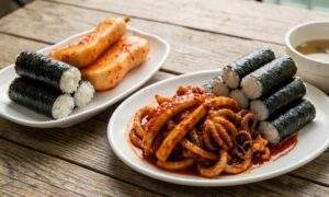 Tongyeong specialty Chungmu Gimbap set served with spicy marinated squid and large radish kimchi.