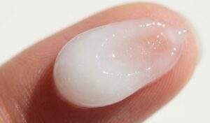 Macro shot of the translucent, milky gel-cream texture of VT Reedle Shot on a fingertip.