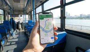 First-person point of view from inside a Seoul Blue Bus, looking at Naver Map app navigation on a smartphone while crossing the Han River towards Yongsan Park