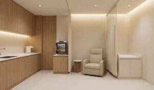 A wide-angle photograph of a clean, modern nursing room in a Korean theme park, featuring a comfortable armchair, a changing station, and a bottle sterilizer.