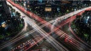 Nighttime view from a luxury hotel window looking down at long-exposure traffic light trails at the busy COEX intersection in Gangnam, Seoul.